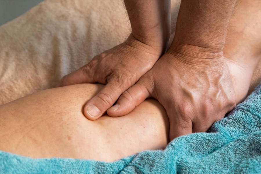 Therapist working on a patient's knee during post-surgical recovery
