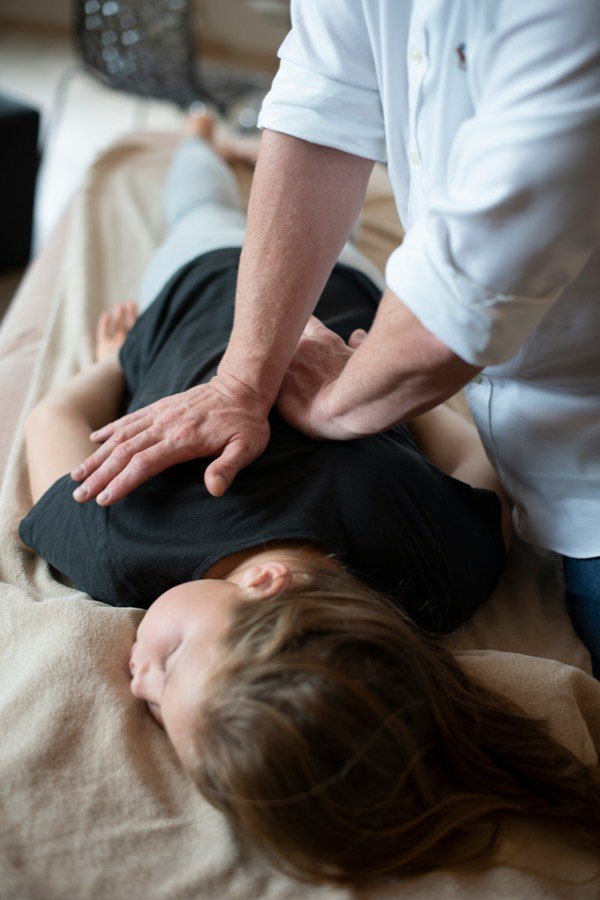 Hands-on manual therapy applied to a patient's back