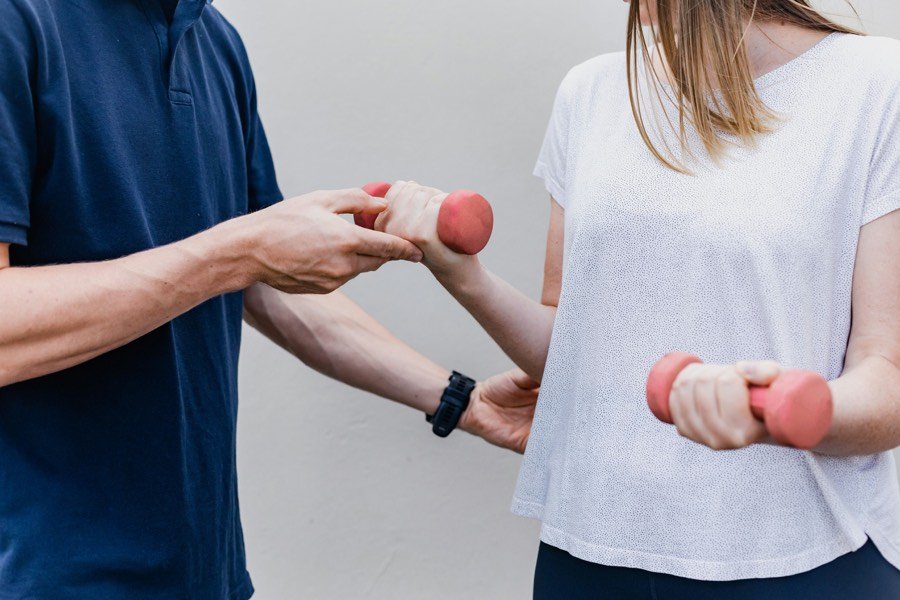 Patient performing guided strengthening exercises with light weights